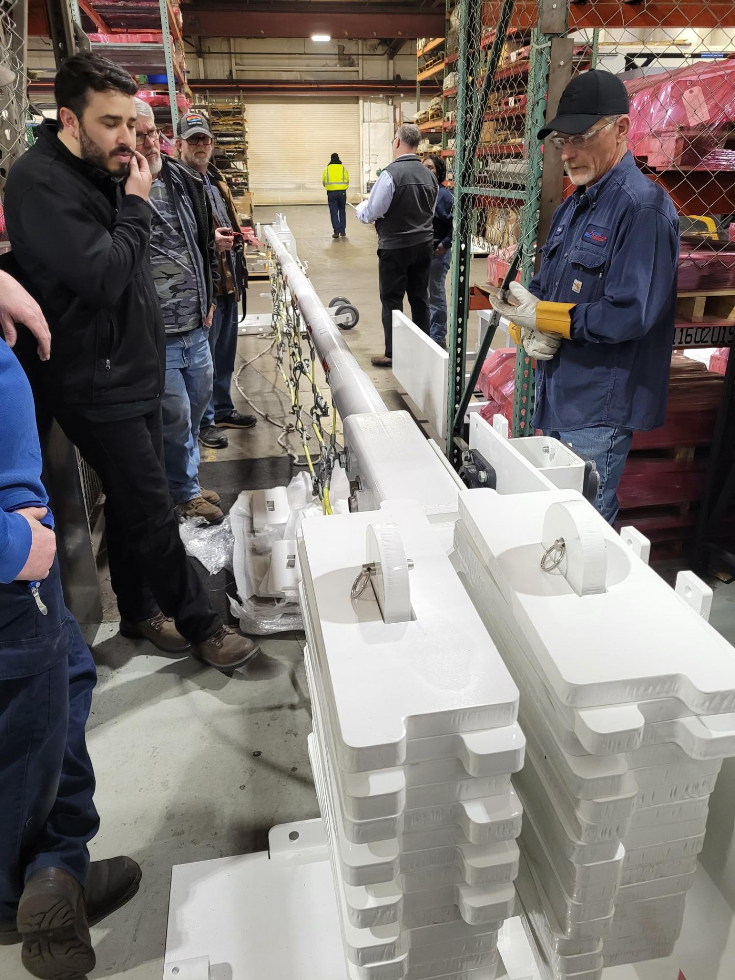 Team inspecting powder coated assemblies on the shop floor