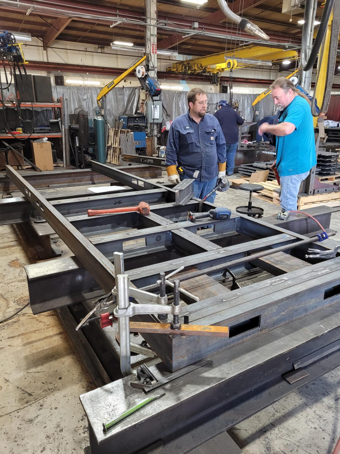 Fabricators working on heavy steel frame assembly